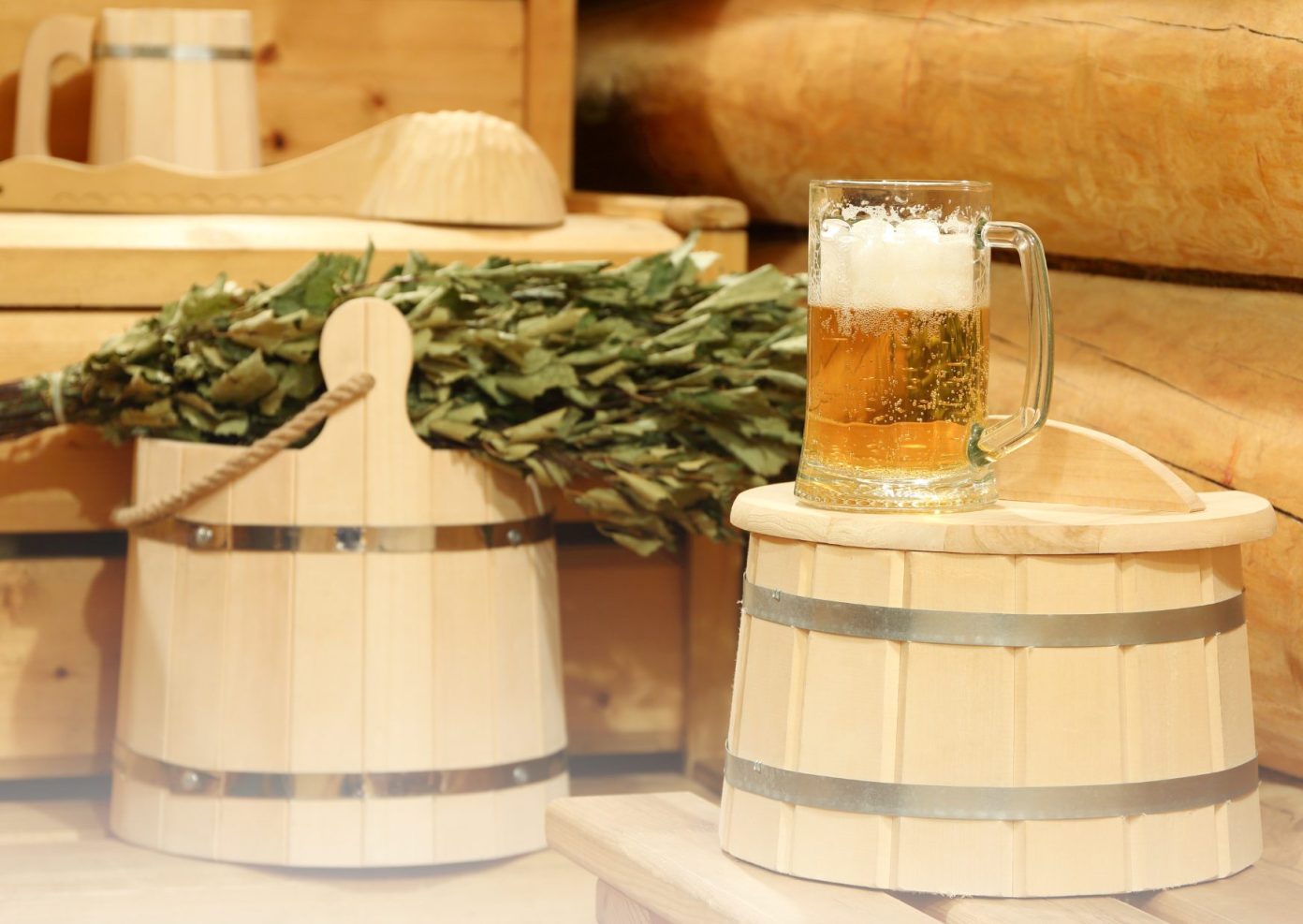 Bild zeigt zwei Saunaeimer mit Birkenzweigen und Bier in einer Sauna. Diese Gegenstände werden beim HOT MONDAY IM WUNNEBAD Winnenden verwendet.